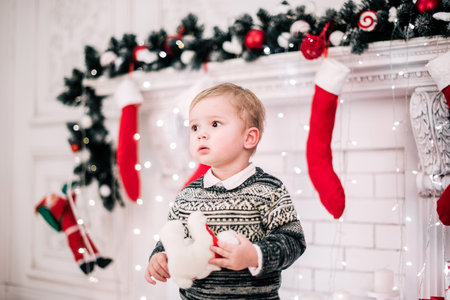 Christmas portrait of a young boy cozy atmosphere around the fireplace and Christmas treeの写真素材