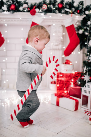 Christmas portrait of a young boy cozy atmosphere around the fireplace and Christmas treeの写真素材