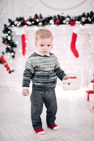 Christmas portrait of a young boy cozy atmosphere around the fireplace and Christmas treeの写真素材