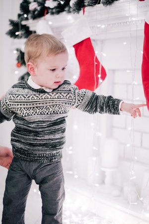 Christmas portrait of a young boy cozy atmosphere around the fireplace and Christmas treeの写真素材