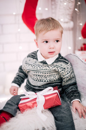 Christmas portrait of a young boy cozy atmosphere around the fireplace and Christmas treeの写真素材