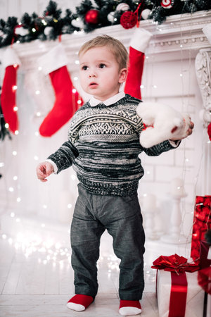 Christmas portrait of a young boy cozy atmosphere around the fireplace and Christmas treeの写真素材