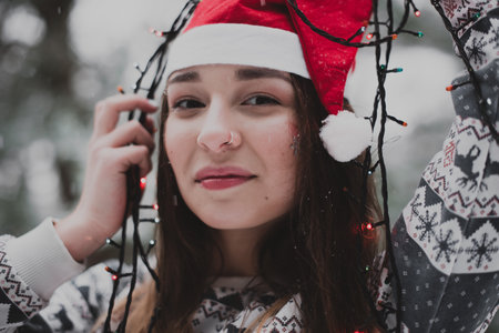Winter portrait of young beautiful brunette woman wearing sweater. Snowing winter beauty fashion concept.の写真素材