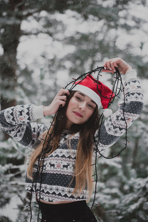 Winter portrait of young beautiful brunette woman wearing sweater. Snowing winter beauty fashion concept.の写真素材