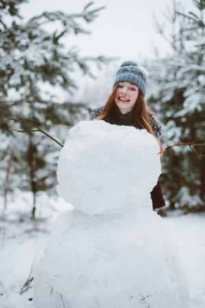 Two young teenage hipster girl friends together.Close up fashion portrait of two sisters hugs and having fun winter time,wearing sweater,best friends couple outdoors, snowy weatherの写真素材