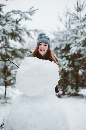 Two young teenage hipster girl friends together.Close up fashion portrait of two sisters hugs and having fun winter time,wearing sweater,best friends couple outdoors, snowy weatherの写真素材