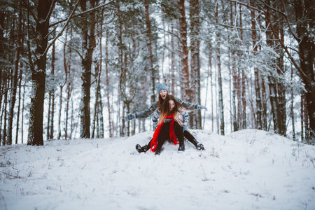 Two young teenage hipster girl friends together.Close up fashion portrait of two sisters hugs and having fun winter time,wearing sweater,best friends couple outdoors, snowy weatherの写真素材