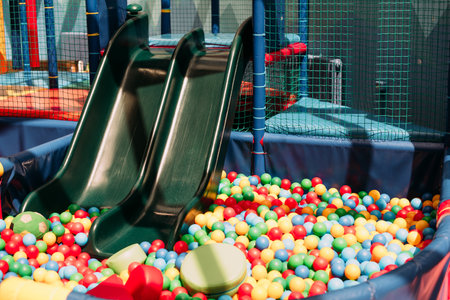 Happy laughing boy 1-2 years old having fun in ball pit on birthday party in kids amusement park and indoor play center. Child playing with colorful balls in playground ball pool. Activity toys for little kid.の写真素材