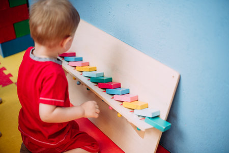 Happy laughing boy 1-2 years old having fun in ball pit on birthday party in kids amusement park and indoor play center. Child playing with colorful balls in playground ball pool. Activity toys for little kid.の写真素材