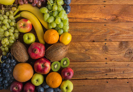 Assortment of raw colorful ripe fresh fruits on wooden backgroundの写真素材