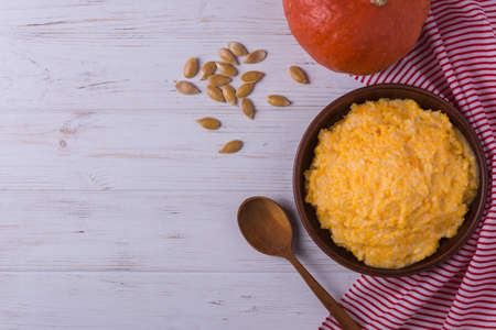 Homemade pumpkin porridge with seeds on white wooden backgroundの写真素材