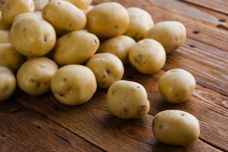 Organic young potatoes raw potato food on wooden backgroundの写真素材