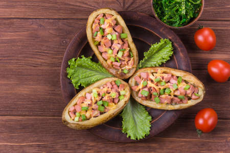 Baked potato with sausage,green onion,lettuce,tomato and spiceの写真素材