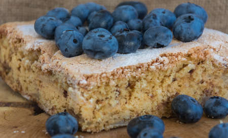 Tasty cake with blueberry on wooden background