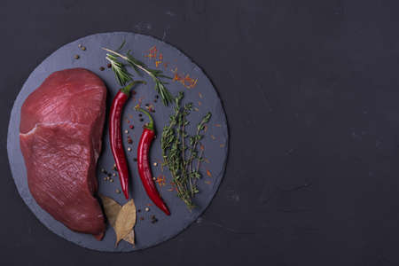 Raw meat beef steak with spice on dark backgroundの写真素材