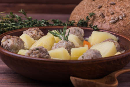 Soup with meatballs with bread and thyme on wooden backgroundの写真素材