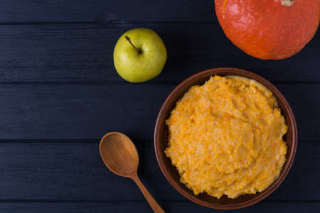 Homemade pumpkin porridge with whole pumpkin and green appleの写真素材