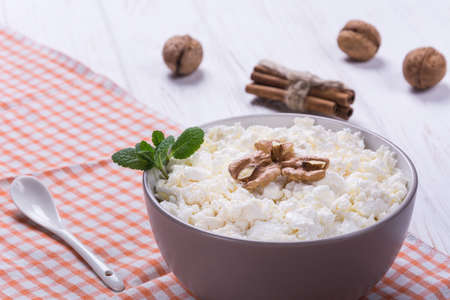Cottage cheese with honey,mint and walnut on white wooden backgroundの写真素材