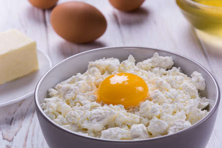Cottage cheese with eggs,baking flour on white wooden rustic tableの写真素材