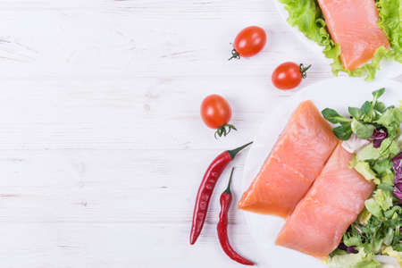 Raw salmon steak with herbs and spice on white wooden backgroundの写真素材