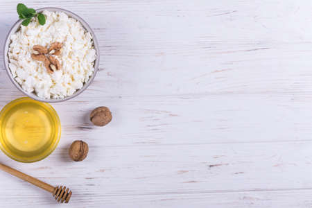 Cottage cheese with honey,mint and walnut on white wooden backgroundの写真素材