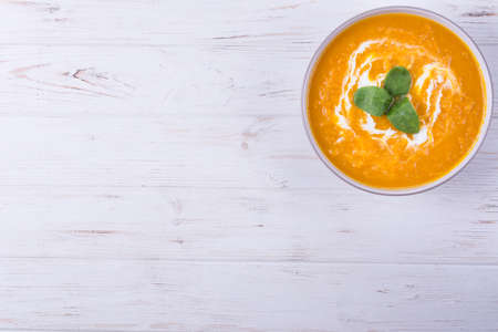 Pumpkin porridge with rice,walnuts and herbs on white wooden backgroundの写真素材