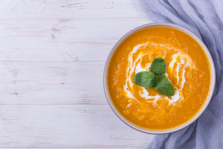 Pumpkin porridge with rice,walnuts and herbs on white wooden backgroundの写真素材