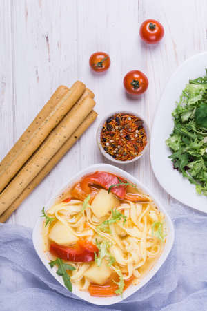 Soup with vegetables,pasta and spice,tomatoes on white backgroundの写真素材