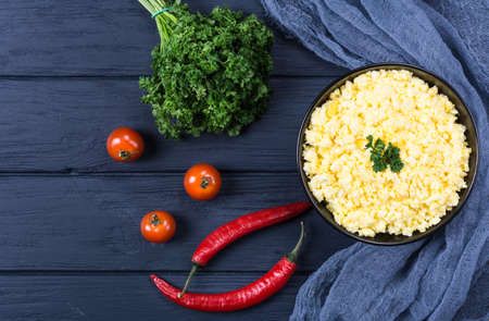 Mashed eggs with tomato and parsley on dark backgroundの写真素材