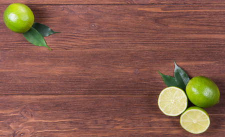 Cut and whole limes on wooden table. Detox dietの写真素材