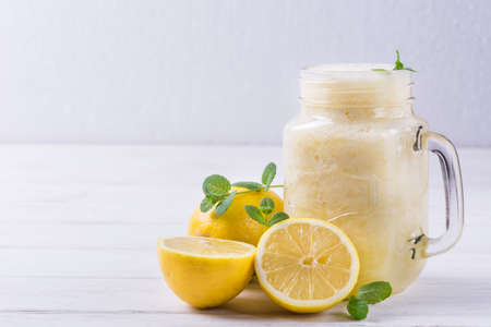 Healthy fresh lemon smoothie in glass jar with ingredientsの写真素材
