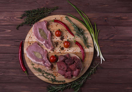 Raw meat beef and pork steak with spice on the wooden cutting boardの写真素材