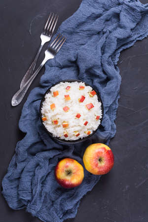 Boiled rice with apples,walnuts and cinnamon on dark backgroundの写真素材