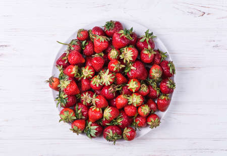 Top of view heap fresh ripe red strawberries in ceramic bowlの写真素材