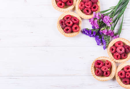 Sweet tartlet with raspberries on white background