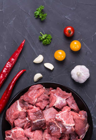 Raw meat beef slices with spice on dark backgroundの写真素材