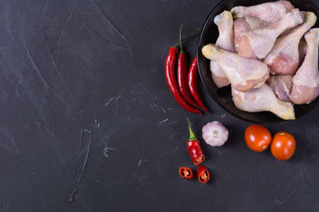 Raw chicken legs with ingredients for cooking