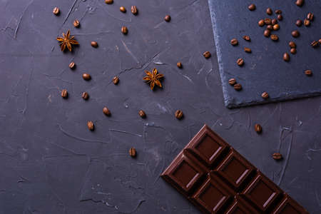 Broken chocolate bar with cofee grains on grey backgroundの写真素材