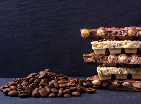 Broken chocolate bar slice with coffee seeds on grey backgroundの写真素材