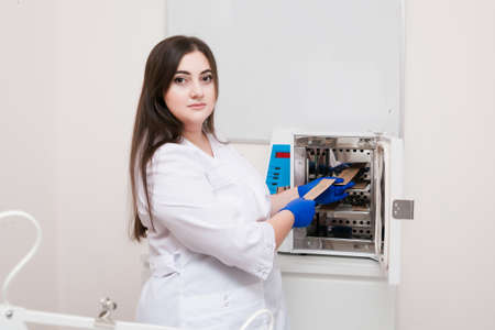 A handsome cosmetologist with long dark hair is performing an electrolysis procedure. In the...