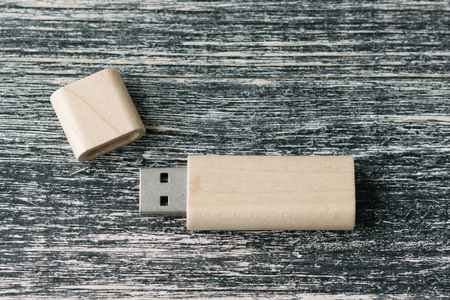 Creative wooden usb stick on dark background. Wooden USB flash drive on white and black table