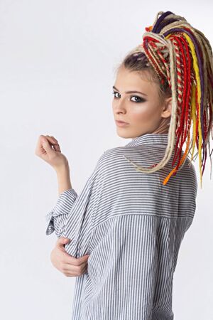 Pretty woman with bright colors dreadlocks. Beautiful sexy woman wearing a stylish fashionable shirt