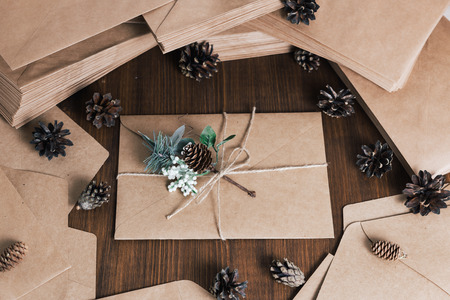 Retro kraft envelop with decorative pine branch with the cone on old wooden tableの写真素材