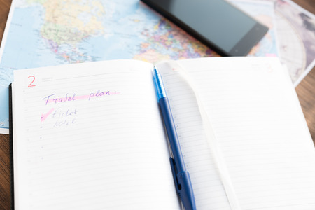 Planner To Do List for trip. Open daily, pen and a phone on the desktop with maps. Travel conceptの写真素材