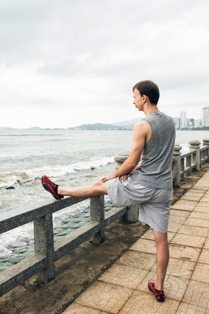Athletic runner doing stretching exercise, preparing for morning workoutの写真素材