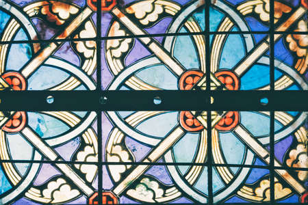Image of a multicolored stained glass window. Stained glass in a cathedral with irregular block patternの写真素材