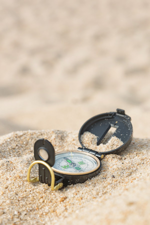 Compass lying on sea hot sand. Vertical viewの写真素材