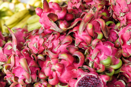 Fresh red dragon fruits and yellow bananas in Vietnamese local marketの写真素材