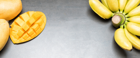 Mango and bananas on black background. Copy space, place for textの写真素材