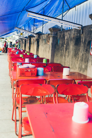 Summer cafe on Bangkok street. Empty red metal tables and chairs on sidewalkの写真素材